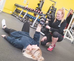 Personal trainer with a client doing floor exercises